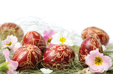 Wax painted Easter eggs with flowers on straw