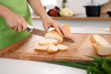 Close up of  woman's hands cooking in the kitchen. Housewife slicing ​​white bread. Vegetarian and healthily cooking concept