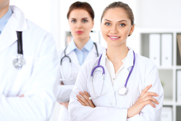 Fototapeta premium Happy female doctor with medical staff at the hospital. Successful team at health care concept