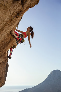 Female rock climber looking up at challenging route