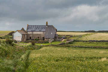 Fototapeta na wymiar Storm passes over a small farm house, The South West Coast Path, Devon, England, UK