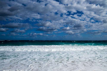 Fototapeta na wymiar A nice tropical beach view of the ocean with clouds in the sky. New Providence, Nassau, Bahamas.