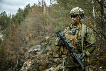 Norwegian Rapid reaction special forces FSK soldier patrolling in the forest. Field camo uniforms,...