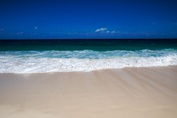 A peaceful tropical beach view of the ocean with a clean blue sky. New Providence, Nassau, Bahamas.
