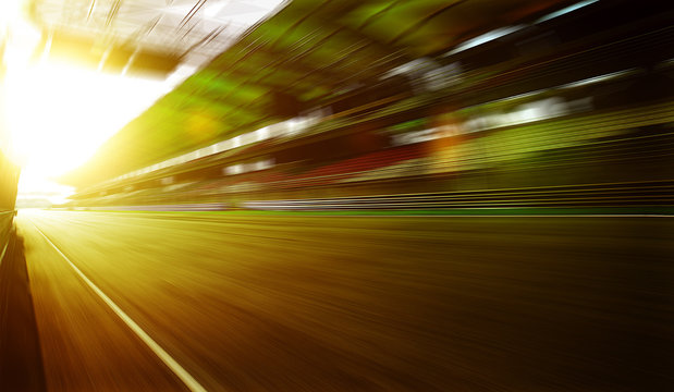 Foward motion speed lens blur racing circuit background with seated stand , sunset scene  .