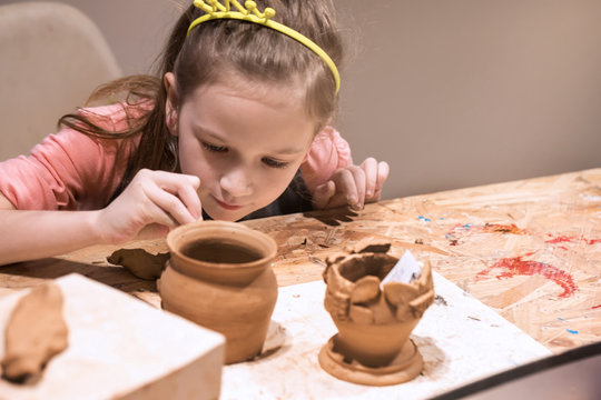 Child sculpts from clay pot. workshop on modeling on the potter's wheel. 
