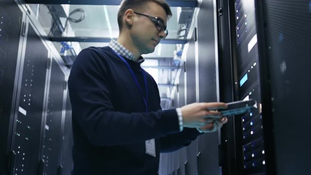 IT Engineer Taking Hard Drives off the Crash Cart and Putting Them into Rack Server. She's Working in Data Center. Shot on RED EPIC-W 8K Helium Cinema Camera.