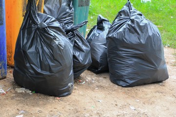 Pile black garbage bag roadside in the city