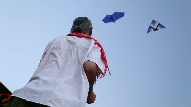 Low angle view of Indian man kiting at beach in Goa.