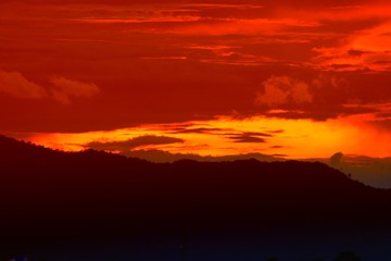 sunset in sky and cloud, beautiful colorful twilight time with mountain silhouette