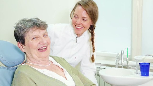 Happy female dentist with patient looking at camera