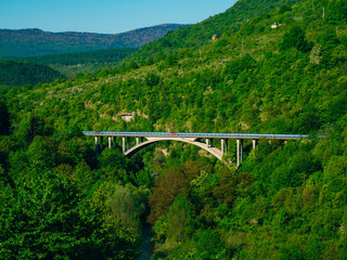 Car arched bridge in the forest, in the mountains. In Croatia, not far from the Plitvice Lakes.