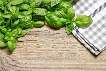 Basil leaves on wooden background.