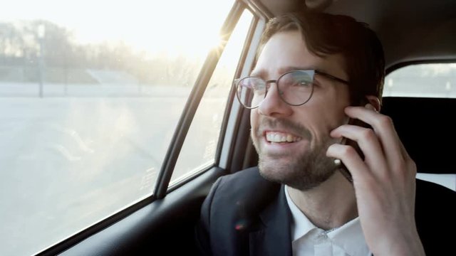 Young Businessman Laughing During a Phone Call