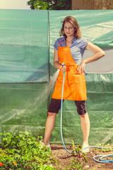 Woman watering the garden with hose
