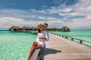 Couple in white on a beach jetty at Maldives