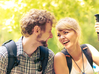 Hiking couple backpackers resting on forest trail