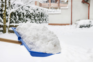 Man removing snow from the sidewalk after snowstorm