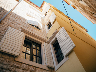 Fototapeta na wymiar White window shutters. The facade of houses in Montenegro.
