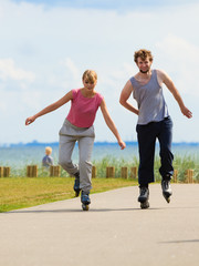 Teen couple together on skates.