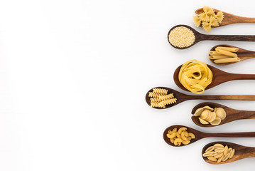 Pasta selection of penne, gnocci, rigatoni, casarecce, fiorelli, pasta Farfalle, pasta A Riso, Orecchiette Pugliesi, Gnocco Sardo and Farfalle in wooden spoons over white background