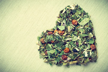 Dried herb leaves heart shaped on jute surface