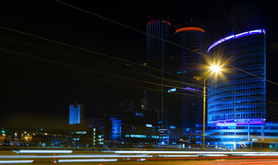 Fototapeta na wymiar night city with business buildings in background lights from cars