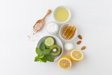 Herbal dermatology cosmetic hygienic cream for beauty and skincare product. honey, lemon, kiwi, cucumber, salt, mint, oil on white background.