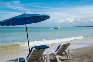 Fototapeta na wymiar Liegestühle und Sonnenschirm am Strand