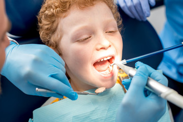 Young boy during the dental procedure at the dental office