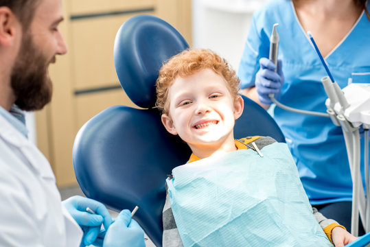 Portrait of a happy young boy with smile sitting on the dental office
