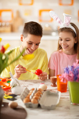 Boy and girl painting Easter egg