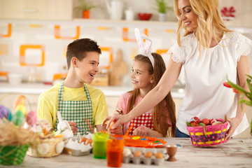 Mother putting colorful eggs in basket