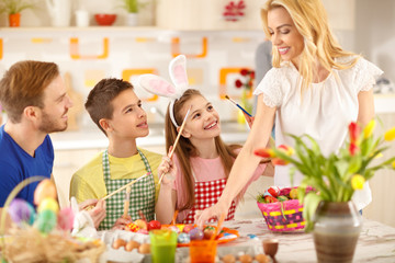 Obraz na płótnie Canvas Mother and children preparing Easter eggs