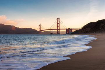 Obraz premium San Francisco beach and Golden Gate Bridge at sunrise, California.
