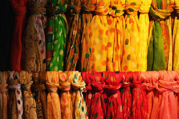  Colorful collection of scarfs hanging on a bar