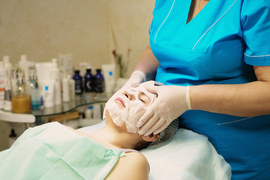 Young woman In Spa Salon With Facial Mask