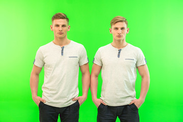 The two twin brother stand on the green background