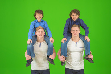 The four cute brothers stand on the green background