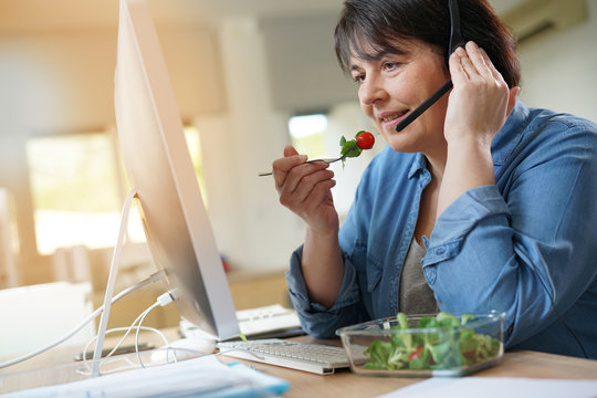 Telemarketing Operator Having Lunch At Work