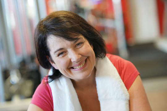 Portrait of cheerful overweight woman at the gym