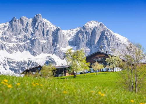 Old traditional farmhouse in front of a snowy mountain range, Kitzbuehel, Tyrol, Austria