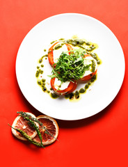 Tasty tomatoes sliced with mozarella cheese and green arugula salad