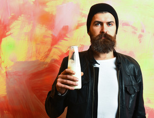 Bearded brutal caucasian hipster holding glass jar of milk