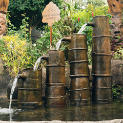 Landscape design, garden decorative waterfall. Beautiful classical garden fish pond with ceramic jar waterfall
