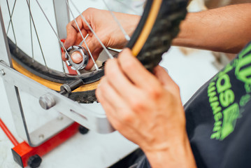 A man working on repairing the wheel of a bicycle