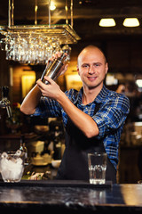 Barman at work,Barman pouring hard spirit into glasses in detail,Bartender is pouring tequila into glass,preparing cocktails,service concept