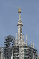 Fototapeta na wymiar Dom in Mailand, Aussenansicht der eingerüsteten Turmpartie mit vergoldeter Marienstatue, Italien