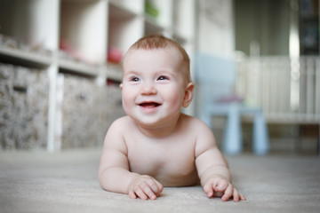 Portrait of a laughing baby in the interior.