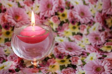 Obraz na płótnie Canvas Floating candle on a floral spring background